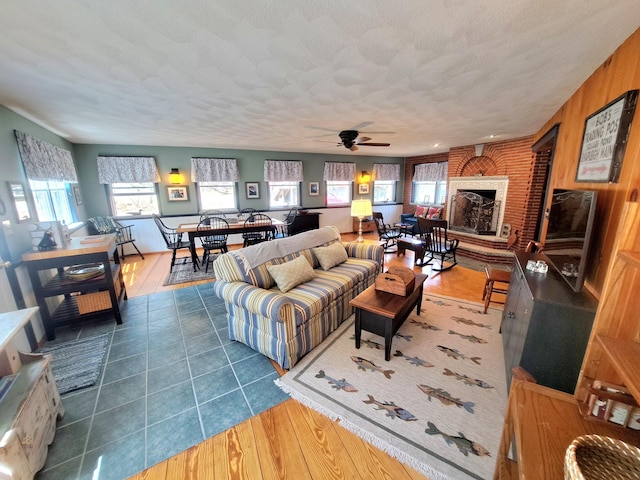 372 Pine Springs Rd, Shapleigh, ME 04076 - living area featuring ceiling fan, a brick fireplace, and wood finished floors