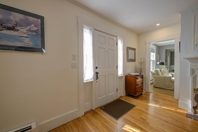 entryway with crown molding, baseboard heating, light wood-type flooring, recessed lighting, and a baseboard radiator