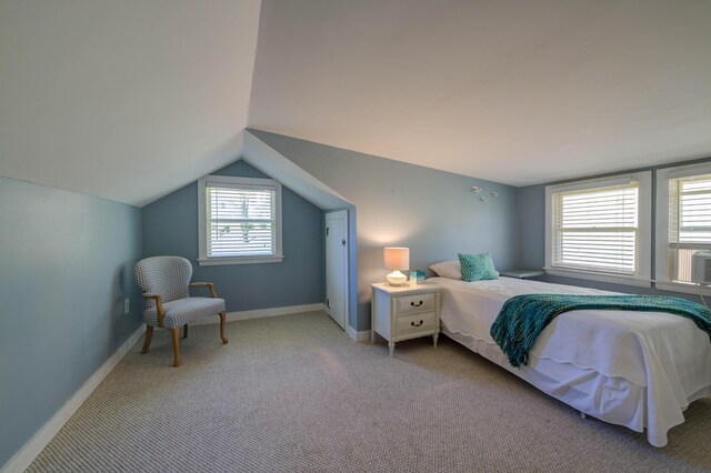 bedroom with baseboards, vaulted ceiling, and carpet