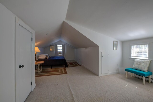 carpeted bedroom featuring baseboards and lofted ceiling