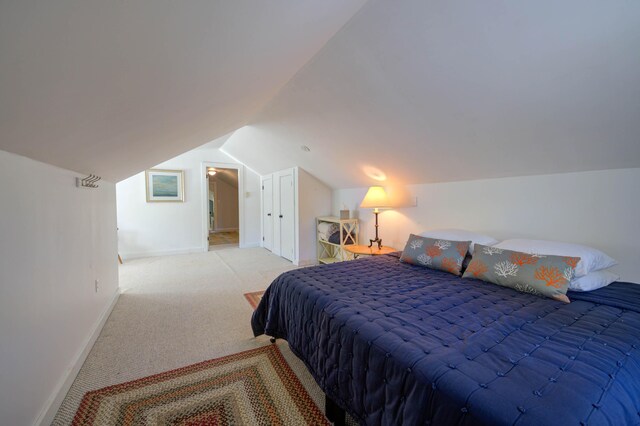 carpeted bedroom featuring baseboards and lofted ceiling