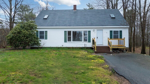 view of front of home with a front lawn, a deck, a chimney, and roof with shingles