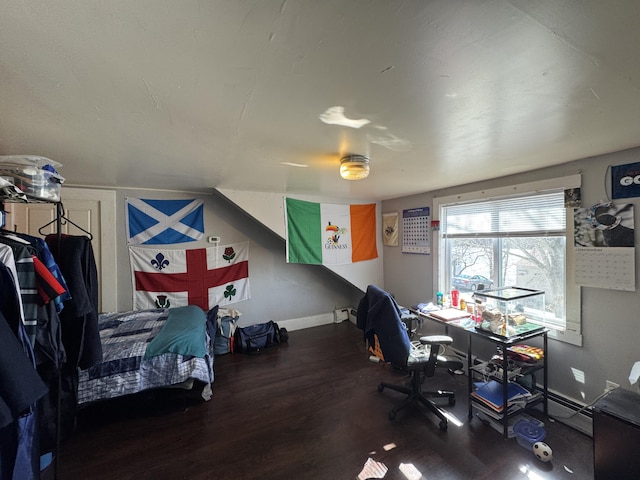 bedroom with baseboard heating, baseboards, and wood finished floors