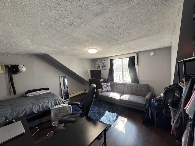 bedroom with a baseboard heating unit, a textured ceiling, and wood finished floors