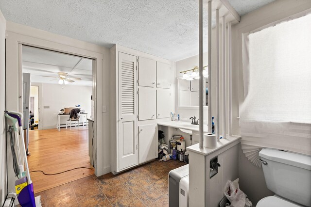 1654 Carl Broggi Hwy, Lebanon, ME 04027 - bathroom featuring a sink, a textured ceiling, ceiling fan, and toilet