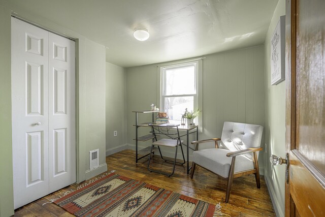 sitting room with visible vents, baseboards, and wood finished floors
