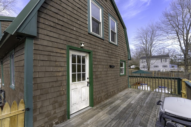 deck with area for grilling and a fenced backyard