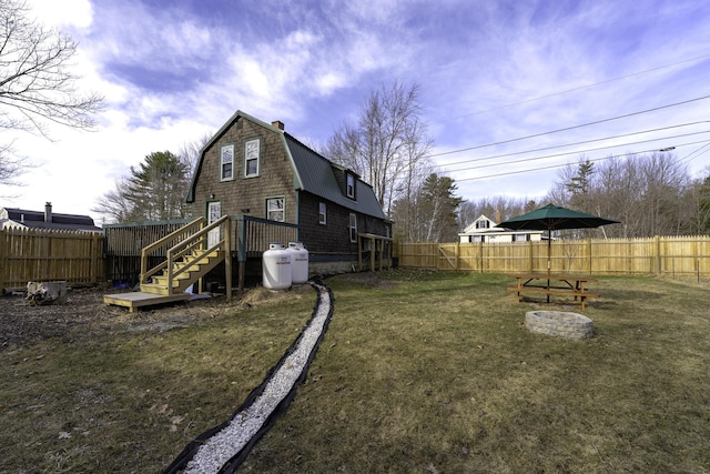 back of property with a lawn, a fenced backyard, and a gambrel roof