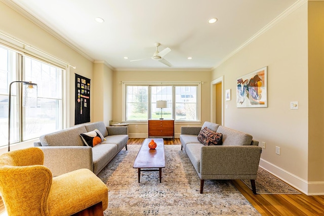 living area featuring crown molding, a ceiling fan, baseboards, and wood finished floors