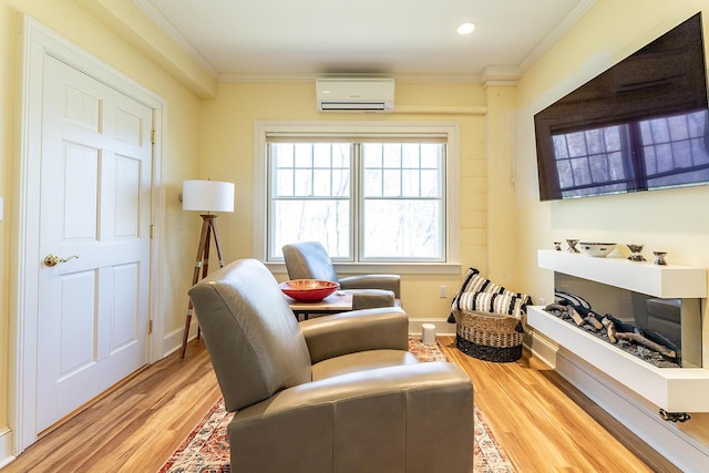 sitting room featuring crown molding, light wood-style floors, baseboards, recessed lighting, and a wall mounted AC