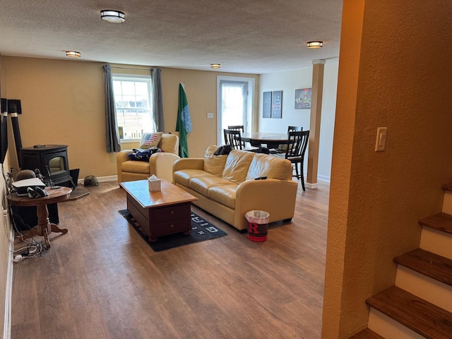129 Williams Rd, Presque Isle, ME 04769 - living area featuring a wood stove, a textured ceiling, stairway, and wood finished floors