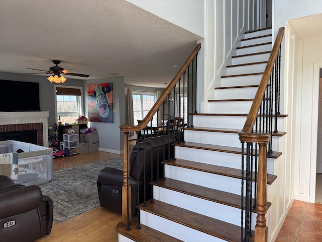 129 Williams Rd, Presque Isle, ME 04769 - stairway with baseboards, a ceiling fan, a fireplace, and plenty of natural light