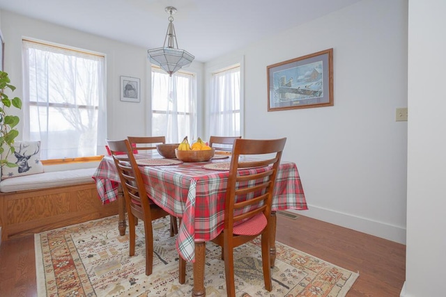 dining space featuring baseboards and wood finished floors