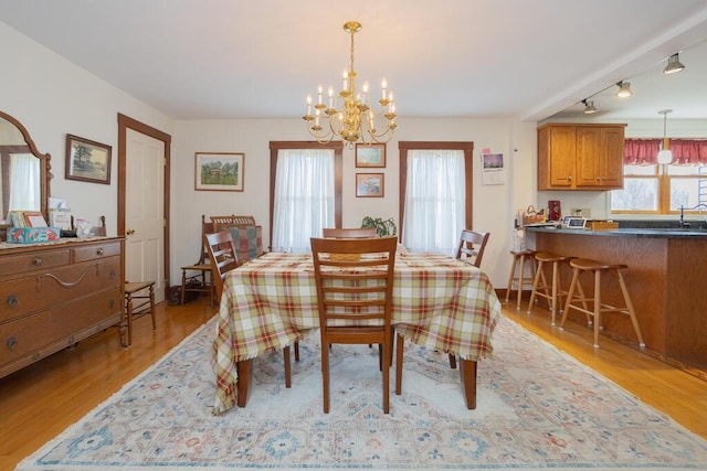 dining room with light wood-style floors and a chandelier