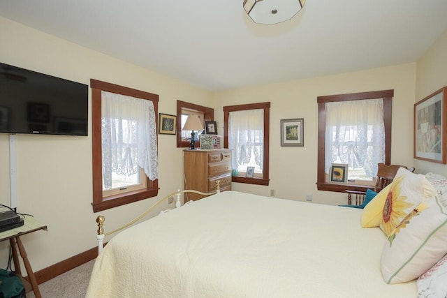 carpeted bedroom with baseboards and multiple windows