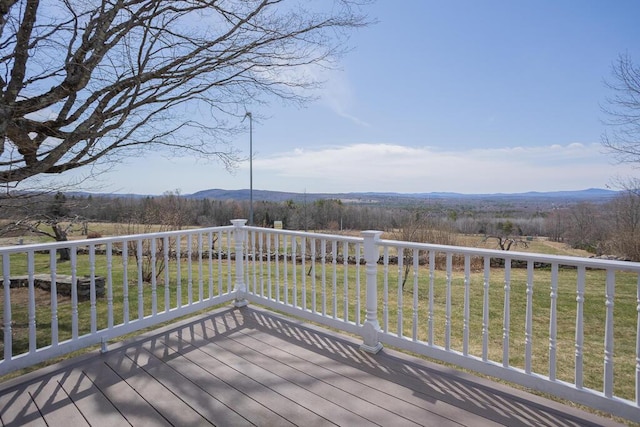 deck with a yard and a mountain view