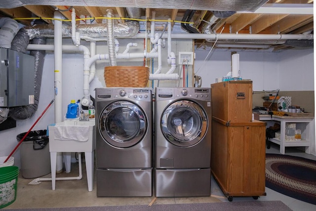 laundry room with laundry area, a sink, and washing machine and dryer