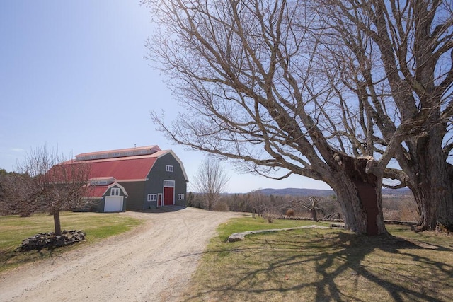 view of street with a barn and driveway