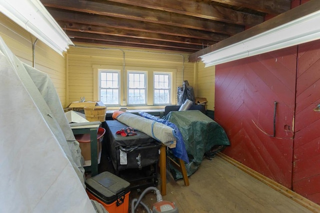 bedroom with wood walls and wood finished floors