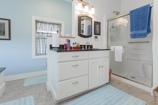 full bath with baseboards, a shower stall, and vanity