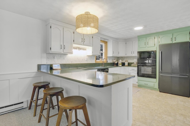 42 Ledge Hill Rd, Raymond, ME 04071 - kitchen featuring a peninsula, a breakfast bar, baseboard heating, a sink, and black appliances