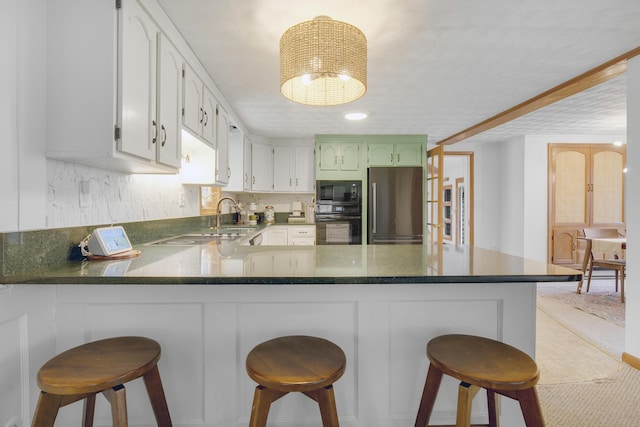 42 Ledge Hill Rd, Raymond, ME 04071 - kitchen with decorative backsplash, a peninsula, a breakfast bar area, a chandelier, and black appliances