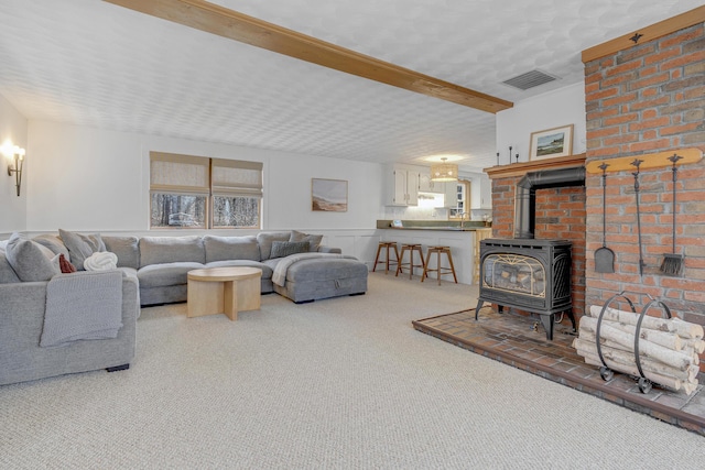42 Ledge Hill Rd, Raymond, ME 04071 - carpeted living area with visible vents, wainscoting, and a wood stove
