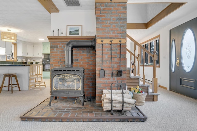 42 Ledge Hill Rd, Raymond, ME 04071 - living area featuring carpet flooring, visible vents, stairs, and a wood stove