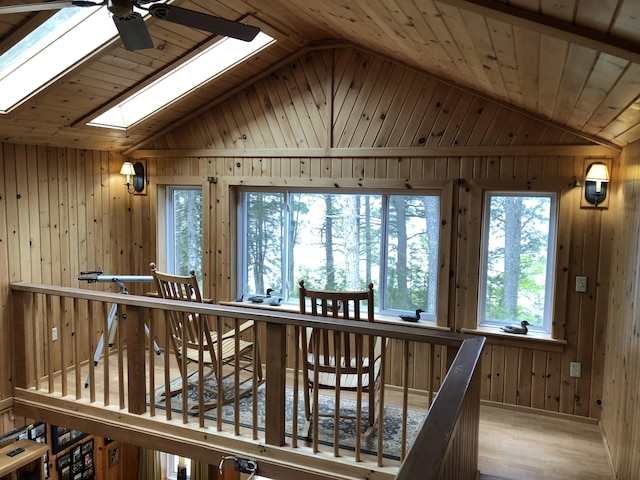 172 Alder Brook Ln, Waltham, ME 04605 - hall featuring vaulted ceiling, wood walls, a skylight, and wood finished floors
