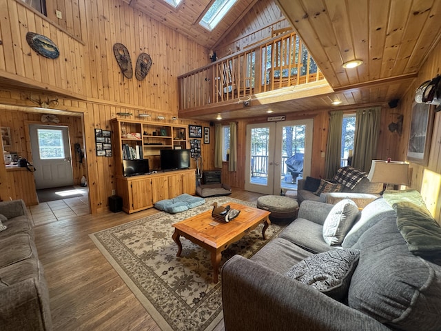 172 Alder Brook Ln, Waltham, ME 04605 - living area featuring wooden walls, a skylight, high vaulted ceiling, french doors, and wood finished floors