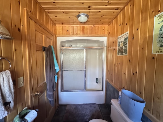 172 Alder Brook Ln, Waltham, ME 04605 - bathroom with wooden walls, toilet, and shower / bath combination with glass door