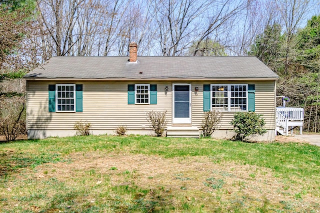 view of front facade featuring entry steps, a deck, a chimney, and a front lawn