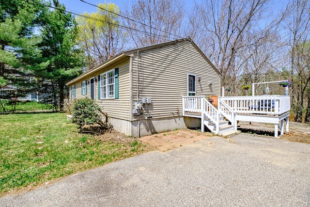 view of front of property featuring a wooden deck and a front yard