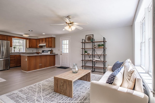 living room featuring recessed lighting, baseboards, ceiling fan, and light wood-type flooring
