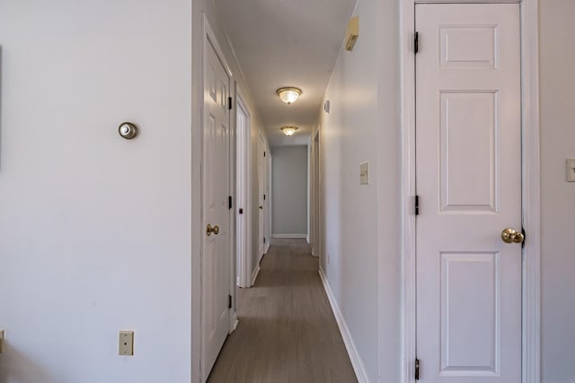 hall featuring baseboards and wood finished floors