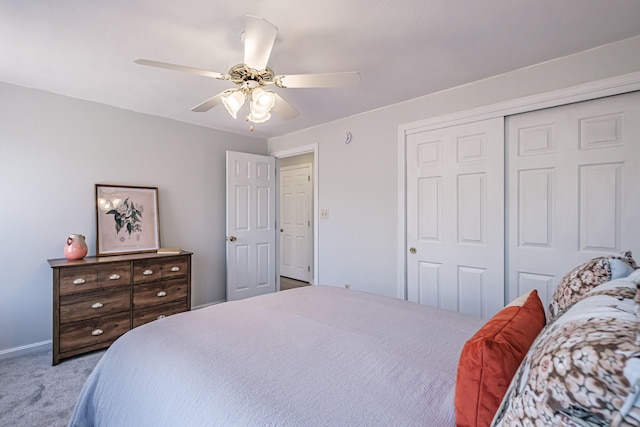 carpeted bedroom with ceiling fan, baseboards, and a closet