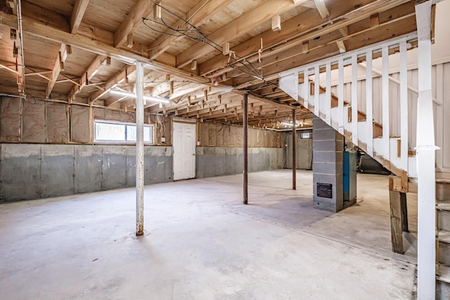 basement with stairway and heating unit