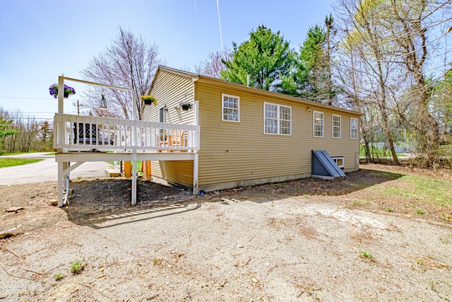 rear view of property featuring a wooden deck