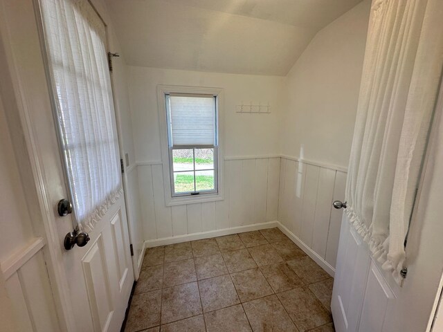 interior space featuring light tile patterned floors and a wainscoted wall