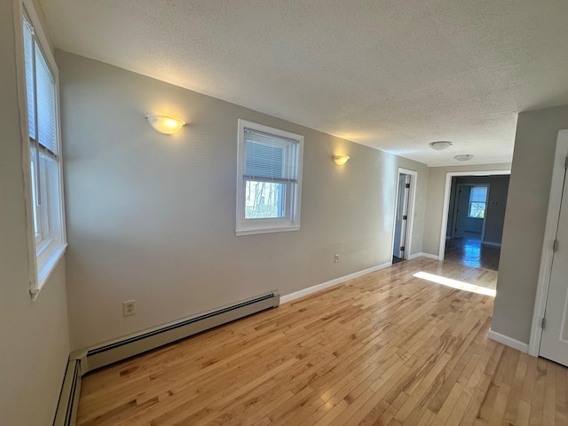 spare room featuring a textured ceiling, a wealth of natural light, and light wood-style flooring