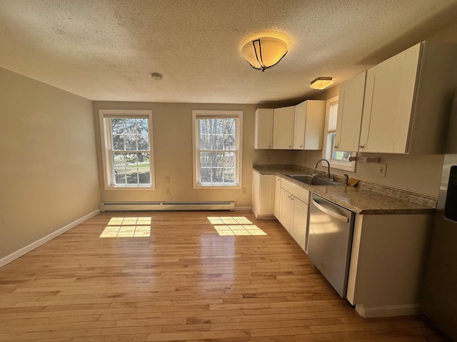 kitchen with stainless steel dishwasher, baseboard heating, a textured ceiling, and a sink