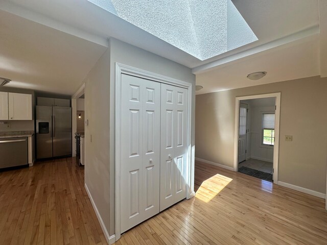 hallway featuring baseboards and light wood-style flooring
