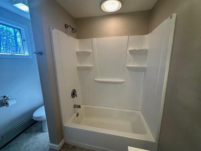 bathroom featuring baseboards, tile patterned flooring, and toilet