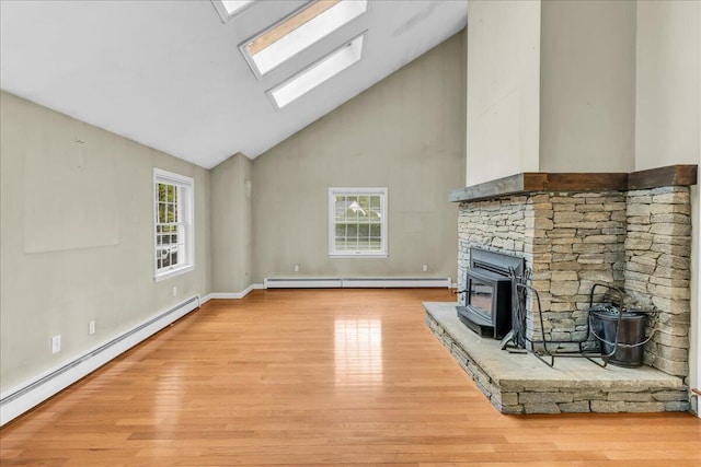 17 Fenton Way, Bangor, ME 04401 - unfurnished living room with a wood stove, a baseboard radiator, high vaulted ceiling, and healthy amount of natural light