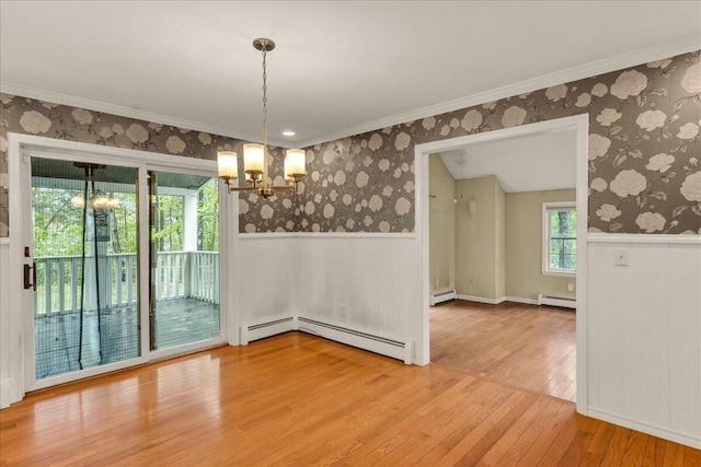 17 Fenton Way, Bangor, ME 04401 - unfurnished dining area featuring a baseboard heating unit, a chandelier, wood-type flooring, a wainscoted wall, and wallpapered walls