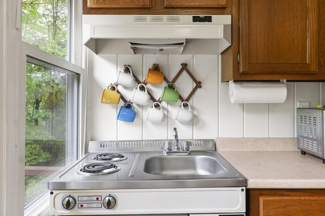19 Pond View Way, Casco, ME 04015 - kitchen with under cabinet range hood, light countertops, brown cabinets, and range