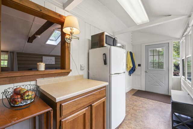 19 Pond View Way, Casco, ME 04015 - kitchen with freestanding refrigerator, stainless steel microwave, a skylight, brown cabinets, and light countertops