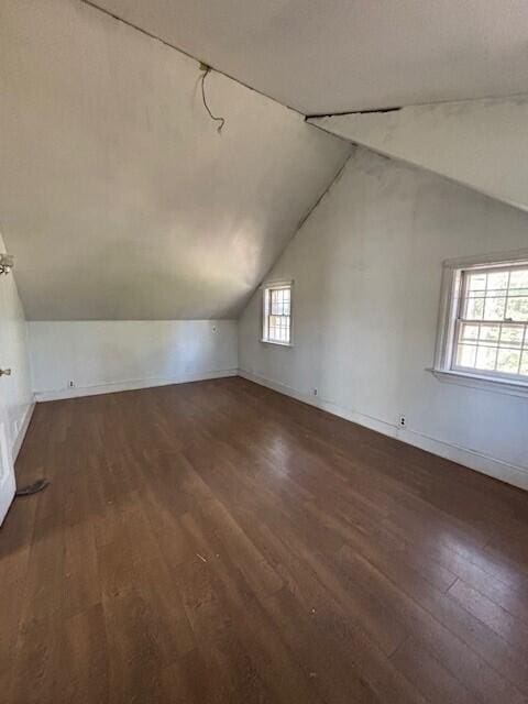 bonus room featuring baseboards, vaulted ceiling, and wood finished floors