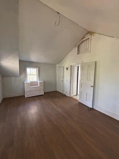 bonus room featuring baseboards, vaulted ceiling, and wood finished floors