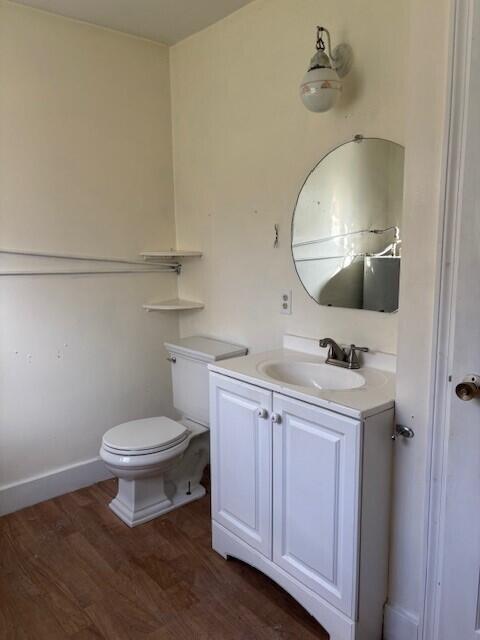 bathroom featuring toilet, wood finished floors, and vanity